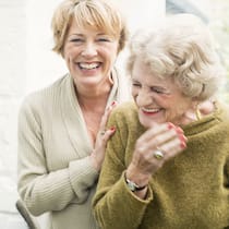 Genügt eine Vollmacht für Mutters Finanzen? Eine Frau mittleren Alters herzt eine ältere Dame.