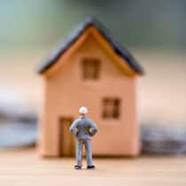 Wie die Kosten im Blick behalten? Ein Spielhaus und eine Spielfigur stehen auf einem Tisch