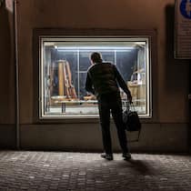 Gedämpfte Lust auf Waffen Mann steht vor Schaufenster eines Waffengeschäfts