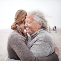 «Wichtig ist, sich auch zu entlasten» Eine Tochter verbringt eine schöne Zeit mit ihrer Mutter an einem Strand und umarmt sie.