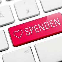Jeder Klick eine gute Tat? Eine extra Taste in rosaroter Farbe auf einer Tastatur, um online spenden zu können.