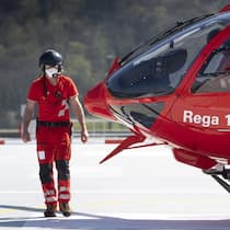 Die Hilfsorganisationen und ihre Millionen Notarzt neben Rega-Helikopter