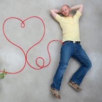 Tipps, damit das Herz nicht schlapp macht Mann liegt auf dem Boden neben ihm sind Gemüse und ein gezeichnetes Herz