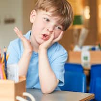 Wie verhaltensauffällige Kinder die Schule fordern Genervter Schüler in Schulzimmer