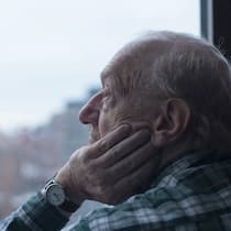 «Ein zurückgezogenes Leben ist ein Risiko» Älterer Mann blickt nachdenklich aus dem Fenster