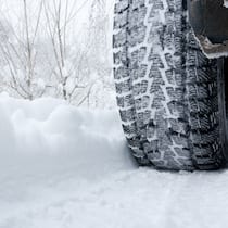 Warum Ganzjahresreifen keine Ganzjahreslösung sind Ein Auto fährt auf einer verschneiten Strasse mit Winterpneus - Es wird wieder Zeit für Winterreifen. Was man dabei beachten muss