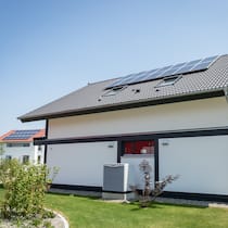 Einsprache gegen Nachbars Wärmepumpe? Ein Fertighaus mit Solarzellen fuer Photovolatik und einer Luft-Luft-Waermepumpe.