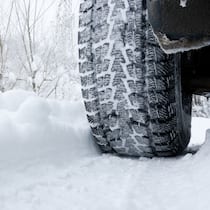 Warum Ganzjahresreifen keine Ganzjahreslösung sind Ein Auto fährt auf einer verschneiten Strasse mit Winterpneus - Es wird wieder Zeit für Winterreifen. Was man dabei beachten muss
