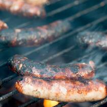 Eskalation am Wurststand Verkohlte Bratwürste auf einem Grill