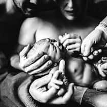 Krise im Kreisssaal Mutter hält Kopf ihres neugeborenen Babys