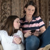 Krieg auf Social Media: So schützen Sie Kinder HWCBJ9 Mother and daughter in living room arguing and holding cell phones