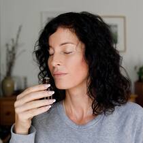 Wenn die Nase ins Training muss 2J9HXCK Woman smelling essential oil from bottle at home
