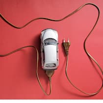 E-Auto mieten statt kaufen – lohnt sich das? Spielzeug-Auto das an einem Ladekabel angeschlossen ist