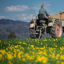 Das wollen die Landwirtschafts-Initiativen Bauer mit Traktor auf Wiese