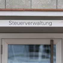 Hier lohnt es sich, die Steuern früh zu zahlen – die Übersicht Eingang des Gebäudes des Steueramts in Liestal BL - Während der Bund den Vorauszahlungsbonus komplett streicht, bieten einzelne Kantone noch Zinsen. Wo es sich am meisten lohnt und wo die Verzugszinsen am höchsten sind.