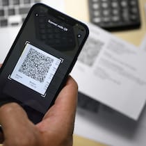 Falsche Rechnungen und Werbefallen – Kriminelle tricksen mit QR-Codes Eine Person scannt mit dem Smartphone eine QR-Rechnung