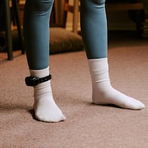 77-Jährige musste Fussfessel tragen – Gericht erlöst sie Füsse einer Person in Socken mit Fussfessel - Nach dem Kauf einer Eigentumswohnung geriet eine Frau ins Visier der Justiz – und musste 20 Monate eine elektronische Fussfessel tragen. Nun zieht das Bundesgericht einen Schlussstrich