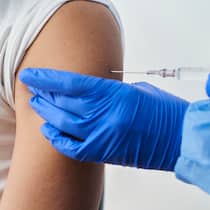 Werden die Nebenwirkungen ernst genug genommen? Eine Medizinfachperson verabreicht eine Impfung in den Oberarm.