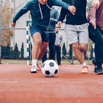 Gefährliche Freizeit für die Gelenke Ein Paar Männer spielen zusammen Fussball.