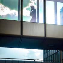 Ein Plädoyer gegen die Vereinzelung Mann am Smartphone geht alleine durch Bürogang