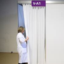 Parlament gegen mehr Transparenz bei Impfstoffbeschaffung Mitarbeitende blickt in Impfzentrum hinter einen Vorhang
