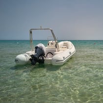 Boot gemietet, Fels gerammt – wer zahlt? Ein Motorbötli dümpelt im seichten Meer, Blick auf den Horizont