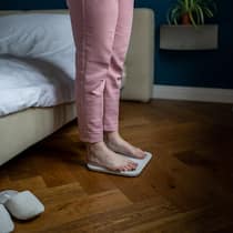 Je weniger man isst, desto stärker wehrt sich der Körper Übergewichtige Frau kontrolliert ihr Gewicht