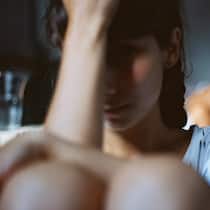«Als wäre eine Vergewaltigung ohne Zwang nicht ‹echt›» Traurige Frau sitzt neben Bett