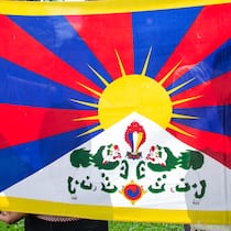 Amt stützt strittigen Geheim-Experten Tibeterin und Tibeter hinter tibetischer Flagge