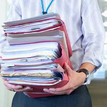 Riesenpleite, aber keine Eile Mann trägt Aktenstapel