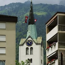 Glarus ignoriert hartnäckig die Realität Eine Kirche und Wohnungen im Zentrum von Schwanden, Gemeinde Glarus Sued, am Sonntag, 4. Juli 2010. Die Gemeinde Glarus Sued, welche juristisch am 1. Januar 2011 ensteht, hat eine Flaeche von 430 Quadratkilometern und ist somit die groesste Gemeinde …