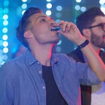 Ist Alkoholsucht vererbbar? Zwei junge Männer trinken einen Shot in einem Club.