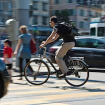 Müssen Velos immer auf dem Veloweg fahren? Ein Velofahrer fährt über einen Fussgängerstreifen. Was im Strassenverkehr für Velofahrer gilt.