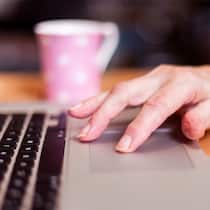 Dank Spenden einen guten Jobstart Frau steuert mit Hand Mousepad von Notebook