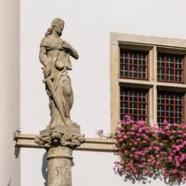 Probleme mit Strafbefehlen – doch die Politik handelt nicht Rathausbrunnen mit Justitia in Brugg, Aargau. Im Hintergrund ein Haus mit einem Fenster mit Geranien