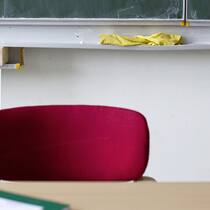 Silvia Steiners kuriose Taskforce Schulzimmer mit Stuhl, Wandtafel und Notizbuch