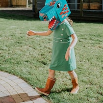 Heim postet ohne Erlaubnis Fotos von fremdplatzierten Kindern Ein Mädchen mit Drachenmaske läuft über eine Wiese.