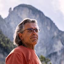 «Was kommt da noch auf uns zu?» Wilfried Meichtry, Autor, posiert fuer ein Portrait neben der Haengebruecke Namens Bhutanbruecke am Fusse des Illgraben in Leuk-Susten, Wallis, am Freitag, 27. Juni 2025.