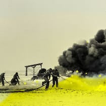 Schweizer Firmen kämpfen für das «ewige Gift» Feuerwehrmänner mit Wendrohren zum Versprühen von Löschschaum in schwarz-weiss mit gelbem Overlay. Die EU will die Industriechemikalien PFAS verbieten. Und stösst auf grossen Widerstand der Lobbys – auch von der Schweizer Industrie.