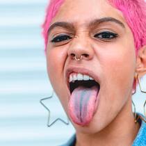 Methylenblau: Der Hype um das gefährliche «Wundermittel» Image of a woman with pink hair sticking out her tongue and wrinkling her face with a candy in her hand.