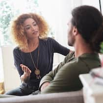 «Reife Liebe braucht Arbeit» Ein junges Paar sitzt zu Hause auf dem Foto und führen eine angespannte Diskussion.