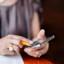 Intrum forderte Geld ohne Grundlage – Schweizerin verliert Bonität Frau mit Handy am Rechnen - Die Inkassofirma Intrum forderte jahrelang Geld wegen angeblicher Roamingkosten. Doch die betroffene Frau hatte nicht einmal einen Handyvertrag