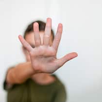 Wenn Hautkrankheiten die Psyche belasten Junge verdeckt Gesicht mit Hand