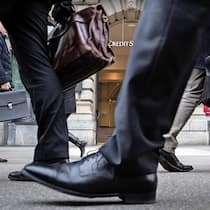 Wie Banken Kunden Geld vorenthalten Menschen in Anzügen vor Credit Suisse