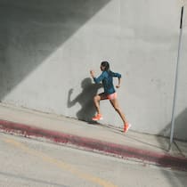 Drei Tage Muskelkater nach dem Training? Sie joggen falsch! Frau joggt einen Hang hinauf - Wenn jede Joggingrunde zur Qual wird, bleibt die Freude auf der Strecke. Lauflegende Markus Ryffel und Sportmediziner Johannes Scherr wissen, wie man Spass am Laufen bekommt