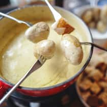 Der Online-Kritiker mit dem schlechten Gewissen Fonduegabeln über einer Schüssel Fondue