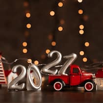 Was ändert sich 2021? Ein rotes Pick-up Spielzeugauto hat auf dem Deck die Zahl 21 geladen. Auf dem Boden steht symbolisch die Zahl 20 für das vergangene Jahr 2020.