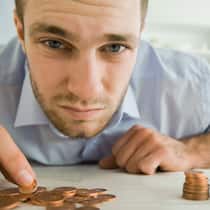 Wie viel Sozialhilfe steht mir zu? Mann sortiert Kleingeld.