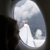 Die Swiss zwingt Passagiere zum Rückflug Swiss: Passagierin blickt aus Fenster auf Flugzeug-Tragfläche. Ein und derselbe Flug kostet einmal Fr. 718.52, ein anderes Mal Fr. 92.55. Günstig fliegt nur, wer Hin- und Rückflug bucht.