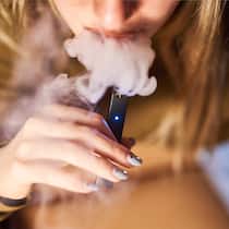 «Mit den neuen E-Zigaretten wird man schneller süchtig» Frau dampft eine Juul-E-Zigarette